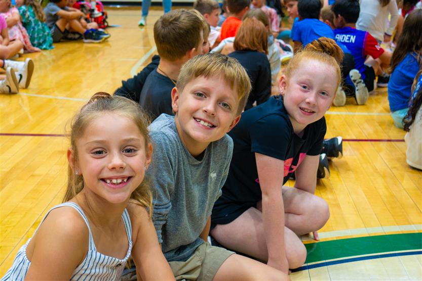 Students smile during an assembly